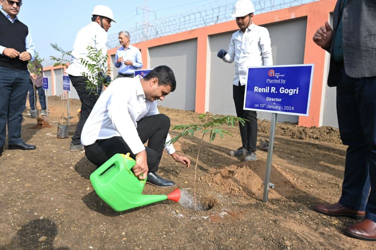 Group photo of Aarti Industries laboratory staff in white coats outside facility entrance