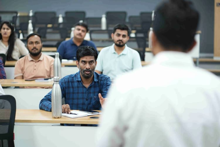 Speaker presenting to seated employees during Aarti Industries training session